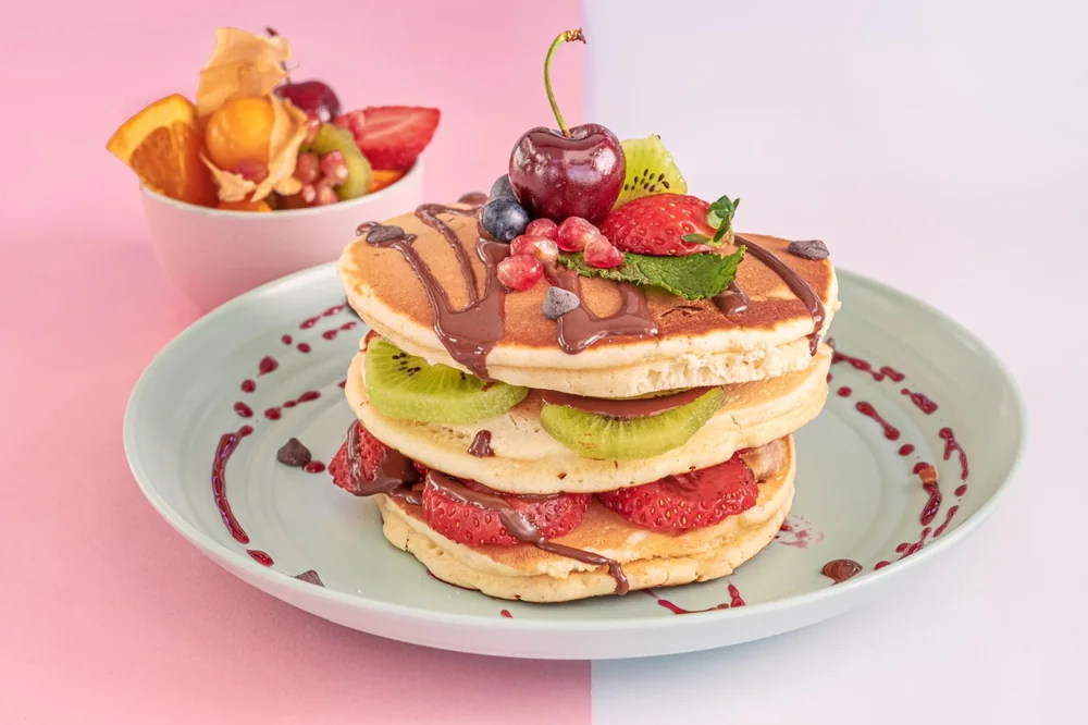 Torre de tortitas con fruta fresca y chocolate